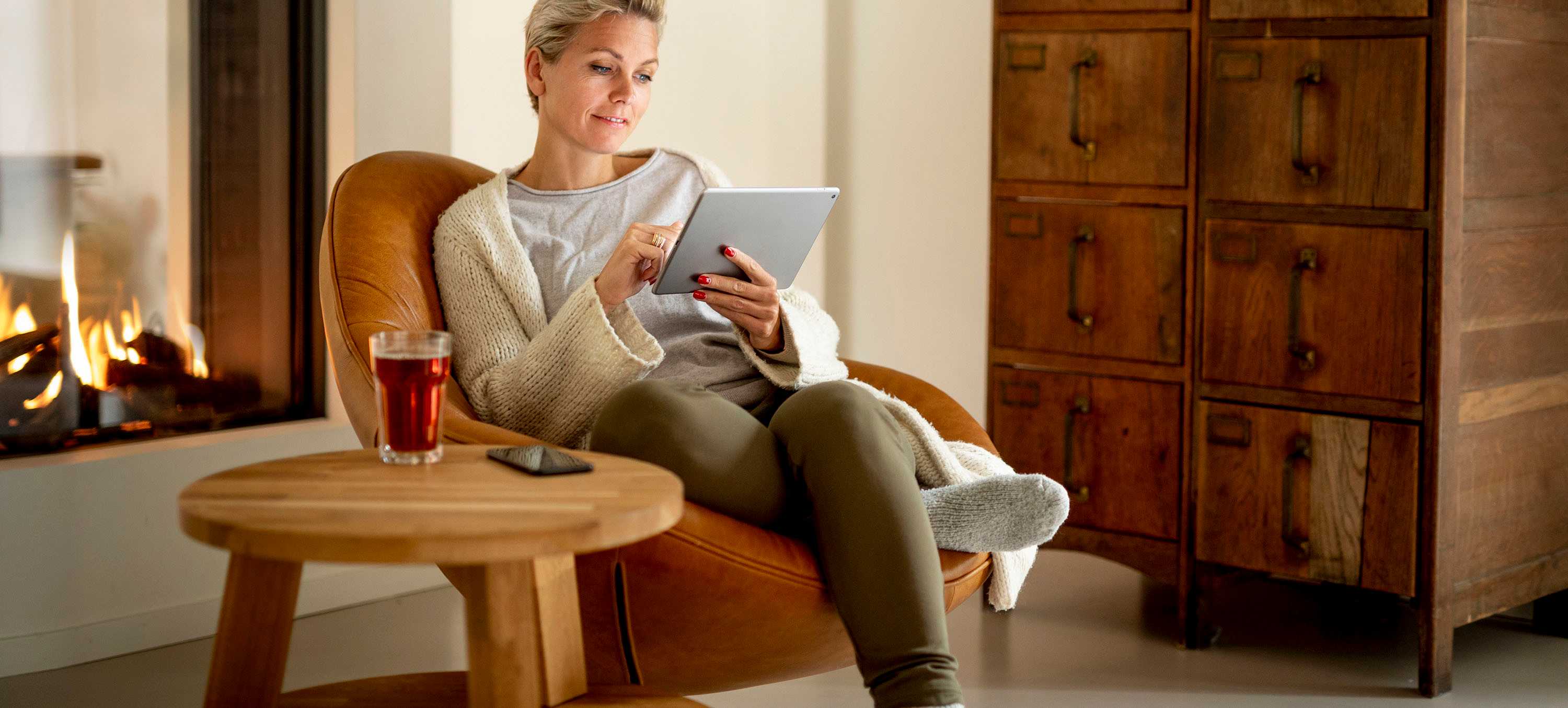 Vrouw bij haardvuur met iPad